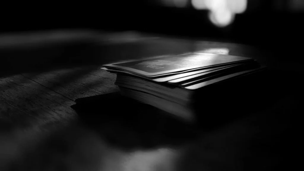 A worn deck of playing cards on a wooden table