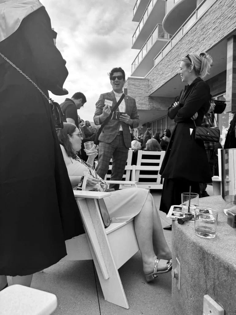 Shayne Slauter moving between groups of guests at a patio reception